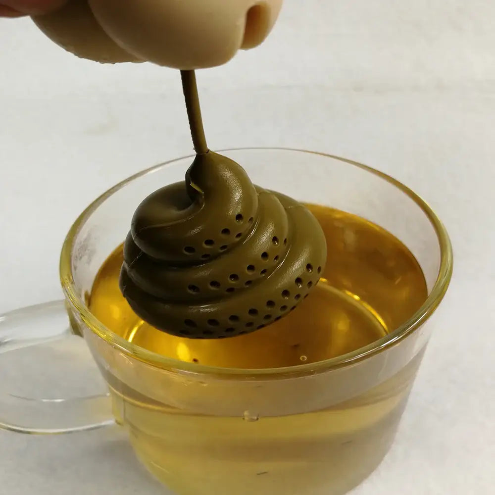 Silicone poop tea infuser steeping loose leaf in a ceramic mug