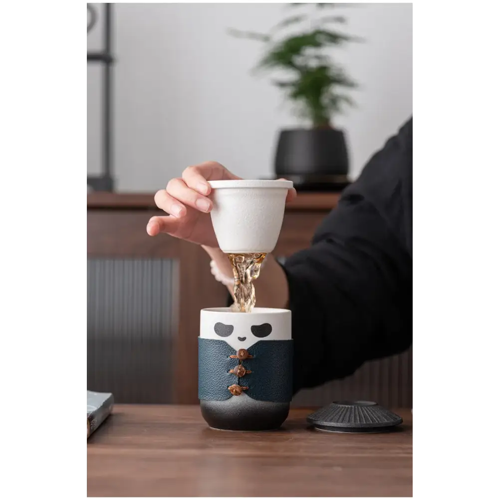 Panda tea infuser sitting on a mug with steam