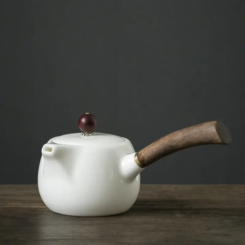 Porcelain teapot with infuser, 19x7cm size, on a wooden table
