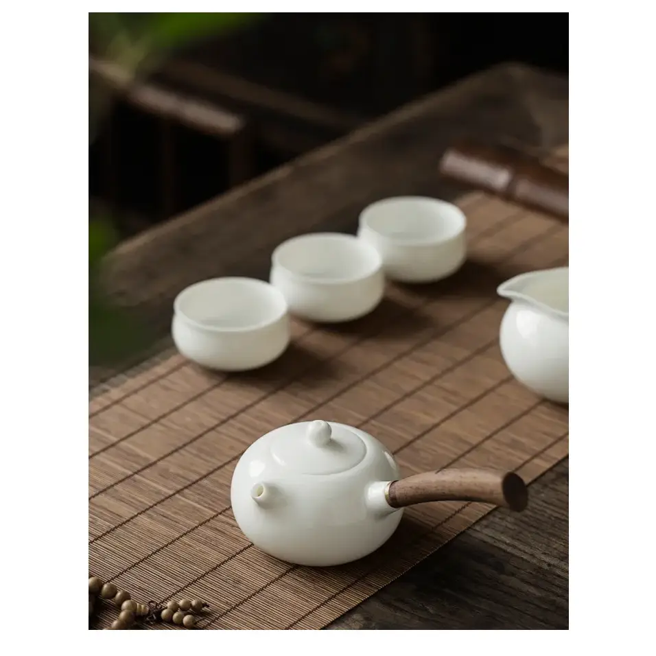 Elegant porcelain teapot with infuser, on a saucer