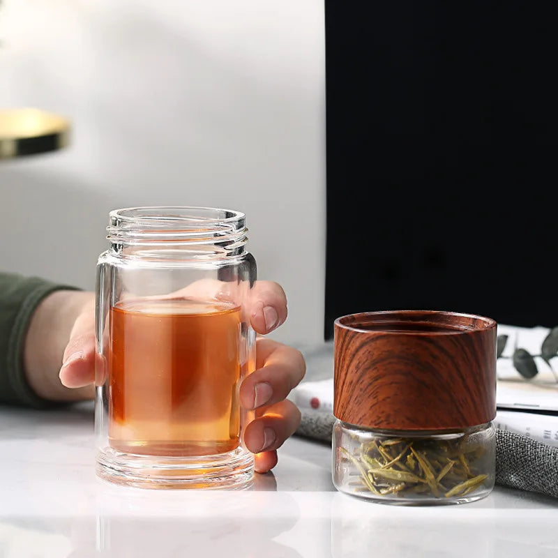 Removable infuser inside glass teapot brewing loose leaf tea, color visible through clear glass