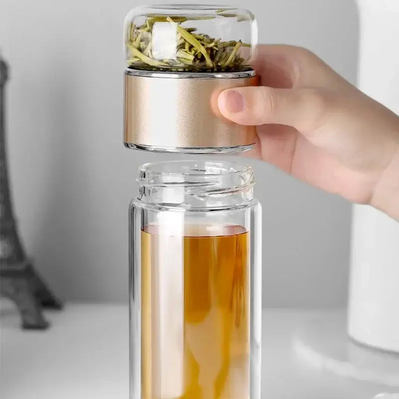 Portable tea infuser bottle with glass body and black sleeve