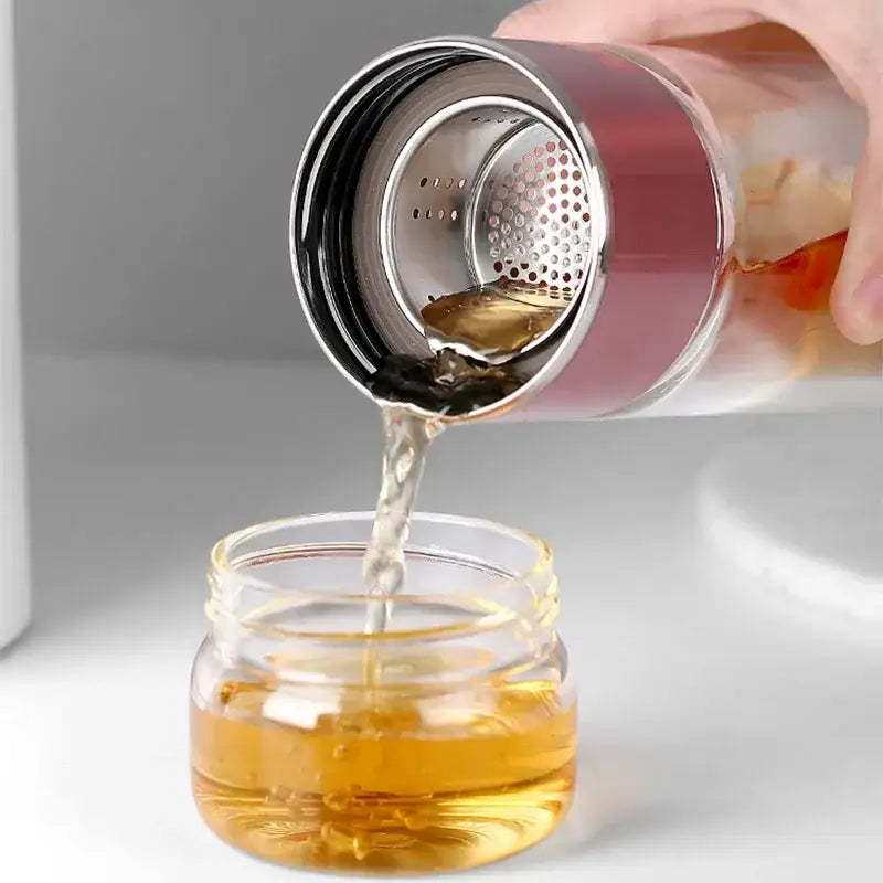 Woman holding portable tea infuser bottle outdoors