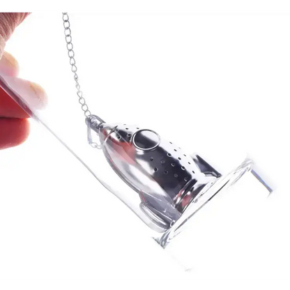 Rocket tea infuser with tea leaves beside it