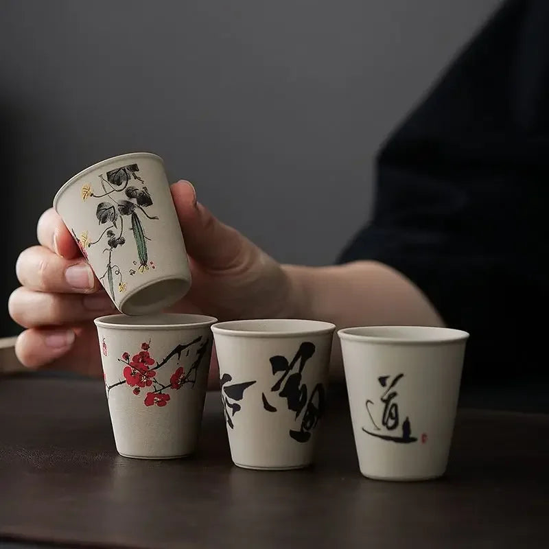 Top view of six raw ceramic cups in warm charcoal and clay tones