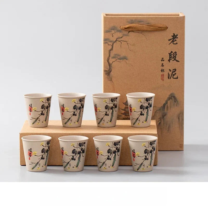 Rustic ceramic tea cups on bamboo tea tray during gongfu cha session