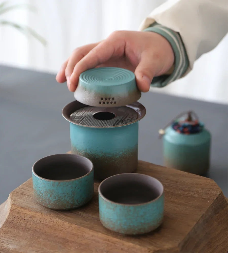 Rustic green teapot set on bamboo tray with tea leaves