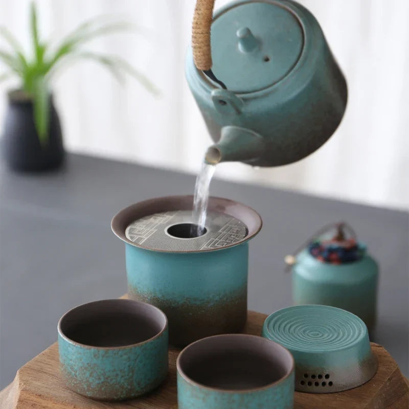 Green ceramic teapot with built-in strainer and two matching cups