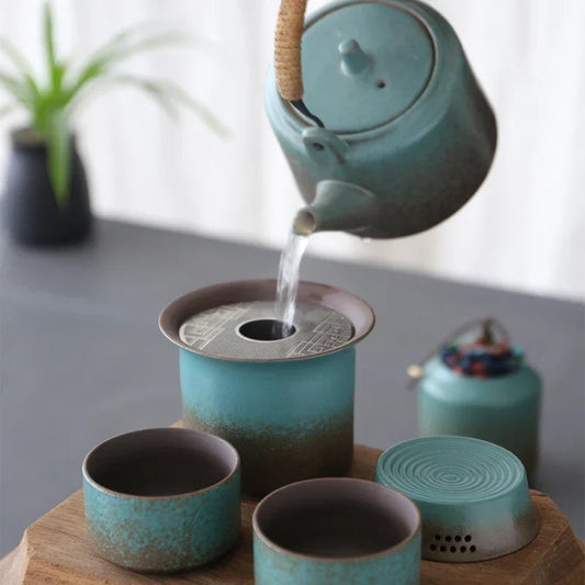 Green ceramic teapot with built-in strainer and two matching cups
