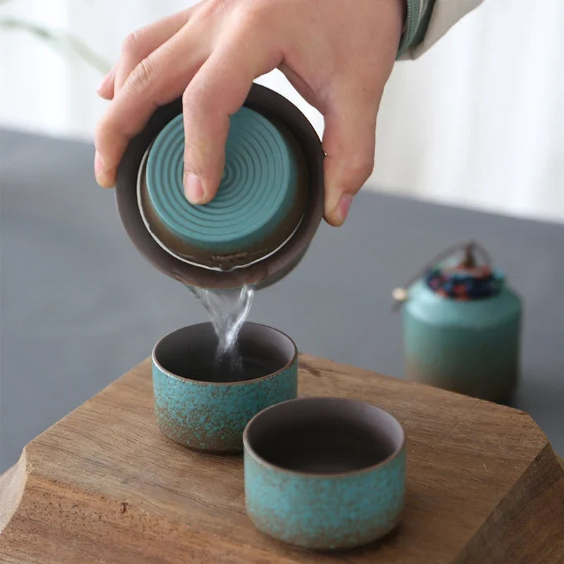Ceramic tea set with tea storage jar and cups on wooden table