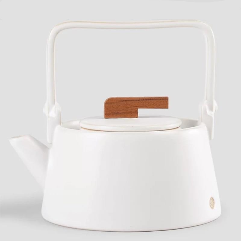 Nordic hygge ceramic teapot with cup and saucer in cozy home setting