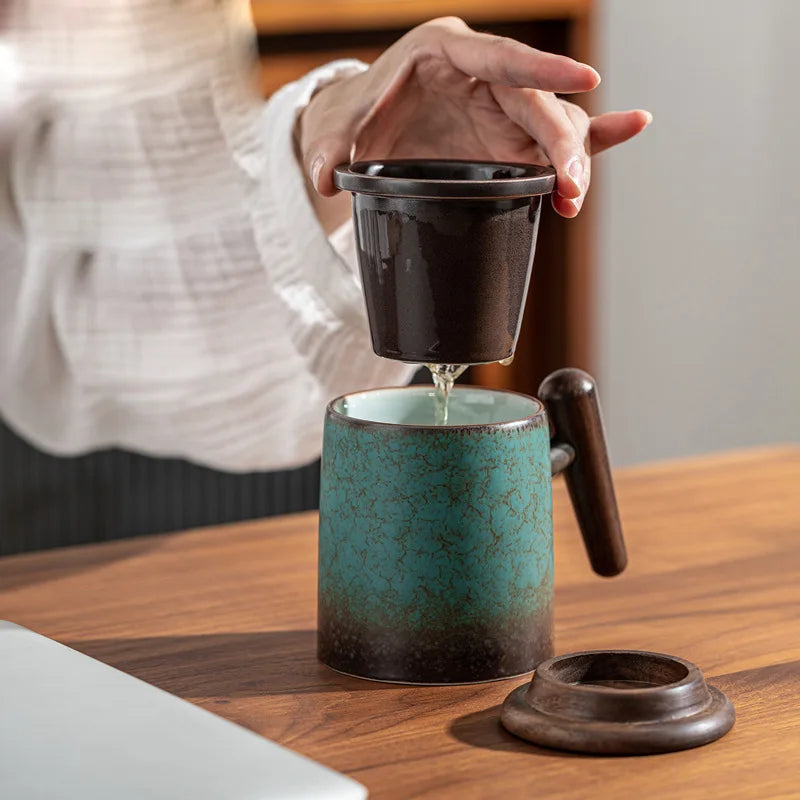 Ceramic teapot with infuser next to a full cup of brewed tea