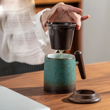 Ceramic teapot with infuser next to a full cup of brewed tea