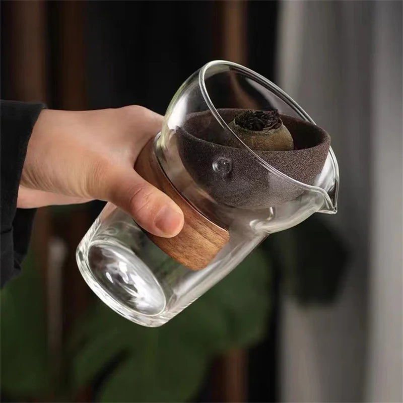 Glass teapot with loose leaf tea steeping inside visible through clear walls
