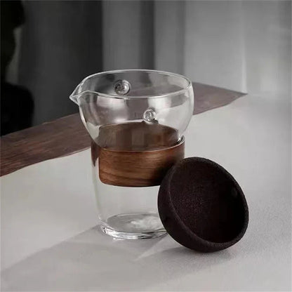 Glass teapot pouring brewed tea into a ceramic cup morning ritual