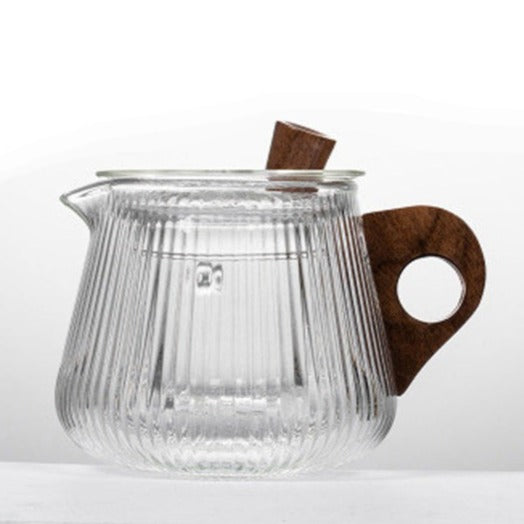 Nordic glass teapot pouring brewed tea into a clear glass cup