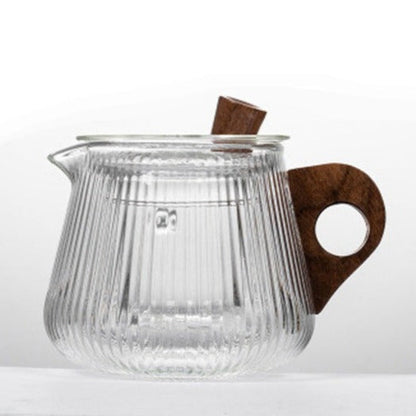 Nordic glass teapot pouring brewed tea into a clear glass cup