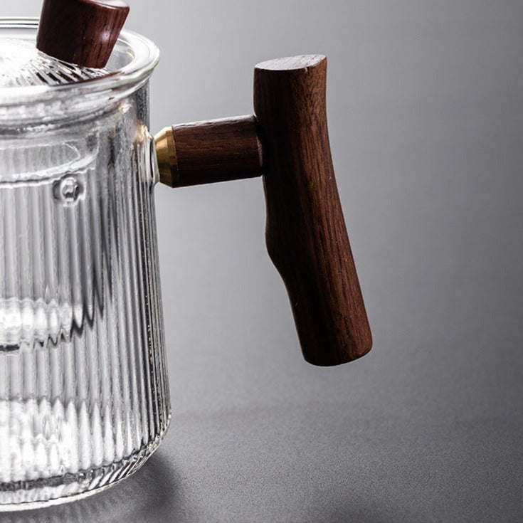 Glass teapot with steam rising, loose leaf tea steeping inside