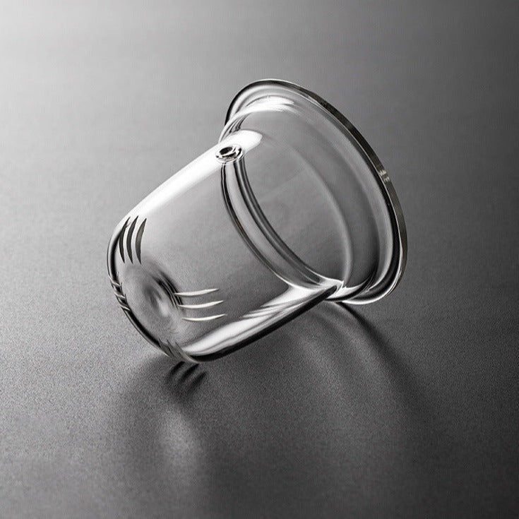 Scandinavian glass teapot beside small cup and saucer, Nordic minimal setting