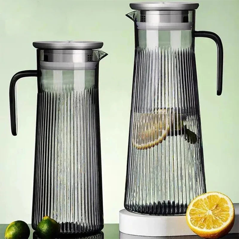 Glass teapot pouring brewed loose leaf tea into white cup