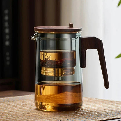 Glass teapot and loose leaf tea cup styled on a Scandinavian linen tablecloth