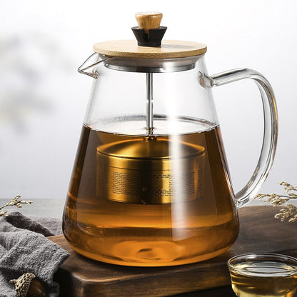 Borosilicate glass teapot with loose leaf tea steeping inside, amber color visible