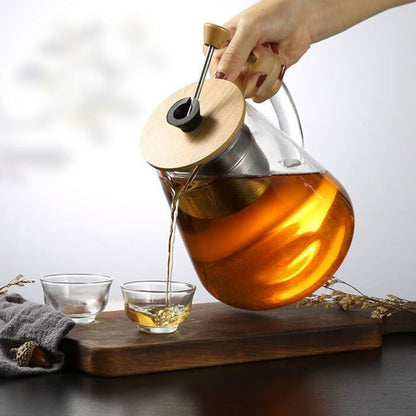 Glass teapot with a filled teacup beside it on a tray