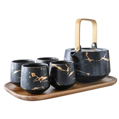 Modern Nordic porcelain teapot Black and Gold, angled view showing spout and lid knob