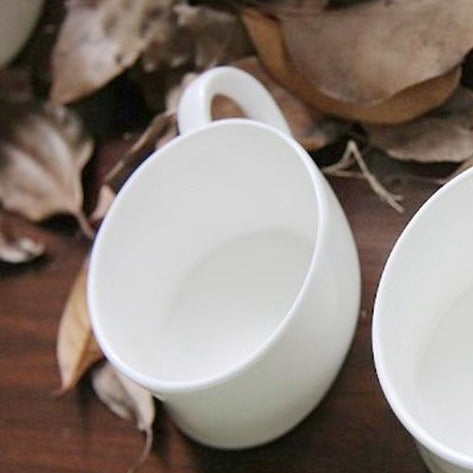 Porcelain teapot with cups in soft light