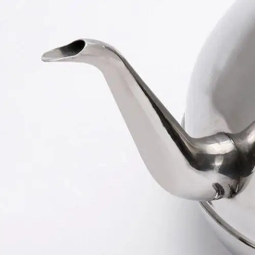 Spout detail on silver oriental stainless steel teapot pouring