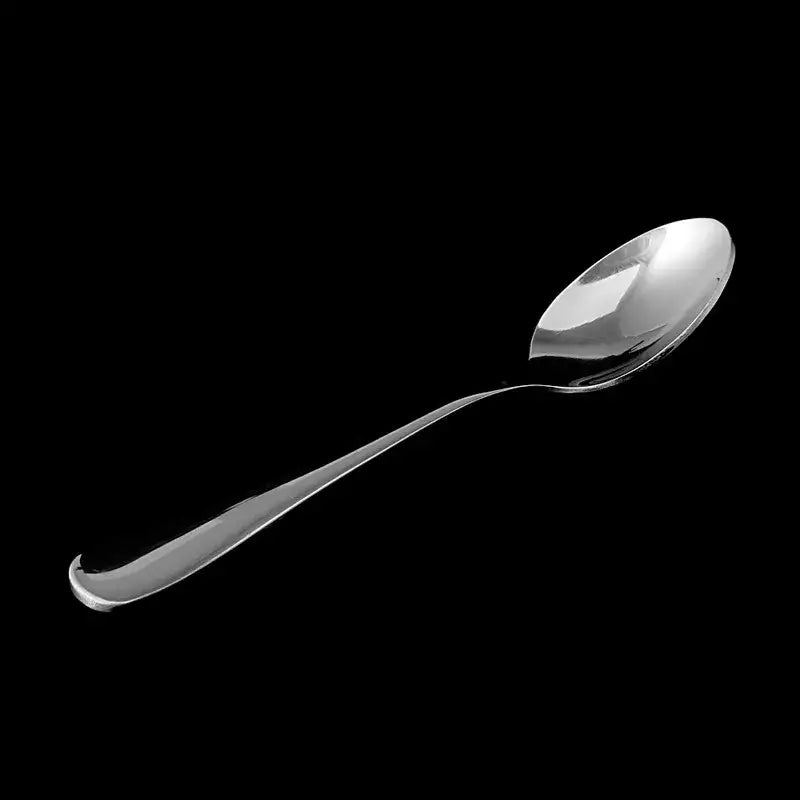 Silver tea spoon with loose leaf tea beside it