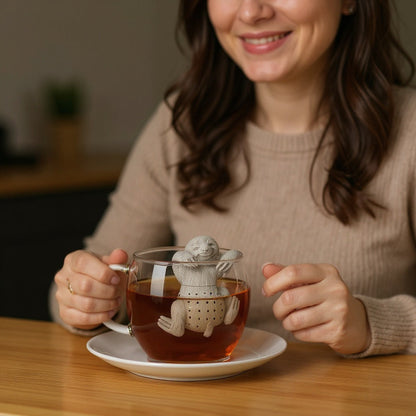 Sloth tea infuser hanging on a cup in use