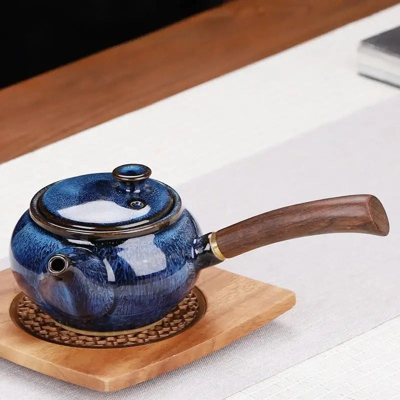 Small ceramic teapot in neutral color on wooden table