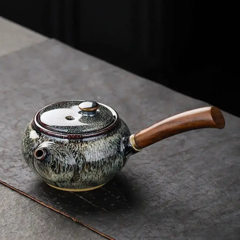 Green small ceramic teapot on kitchen counter