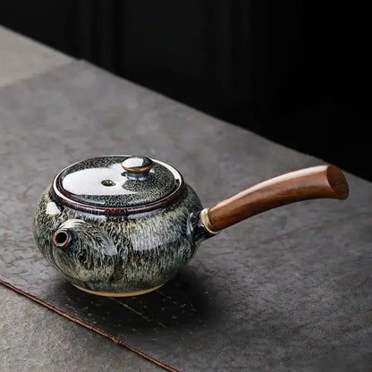 Green small ceramic teapot on kitchen counter