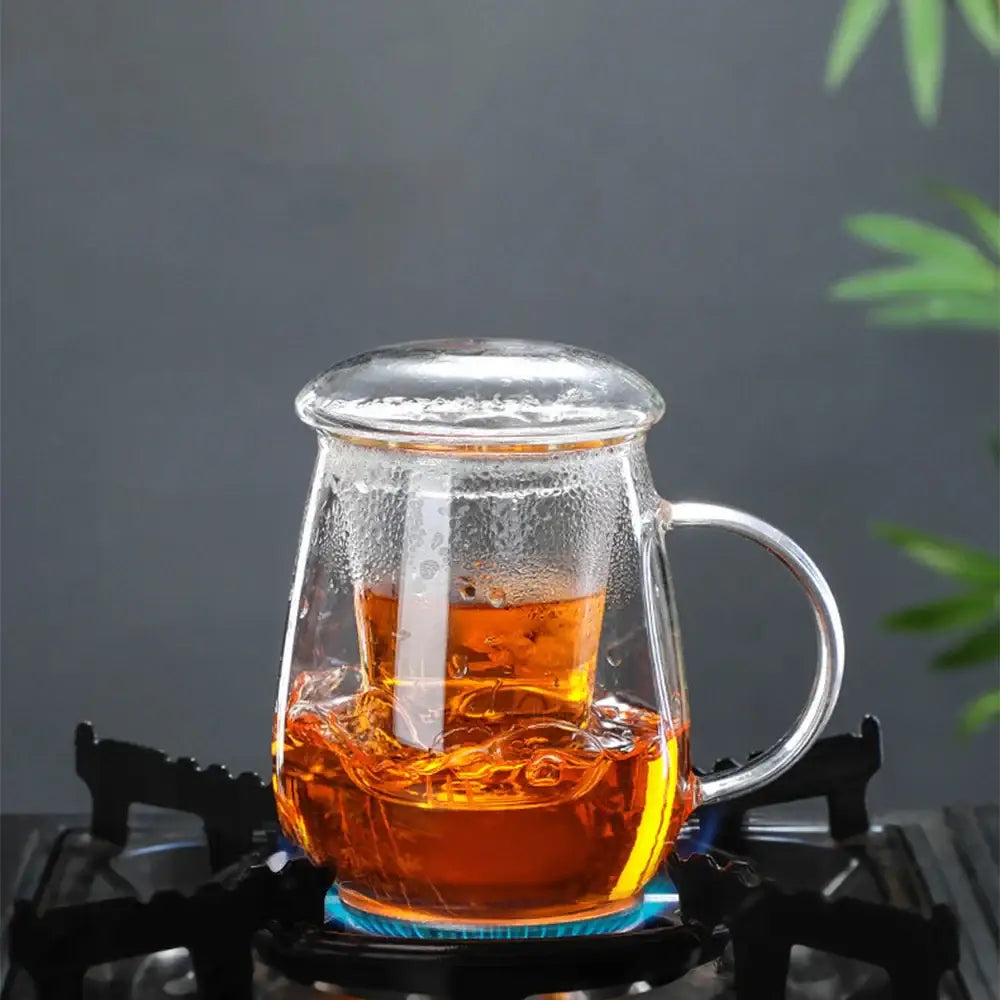 Pouring tea from small glass teapot into cup