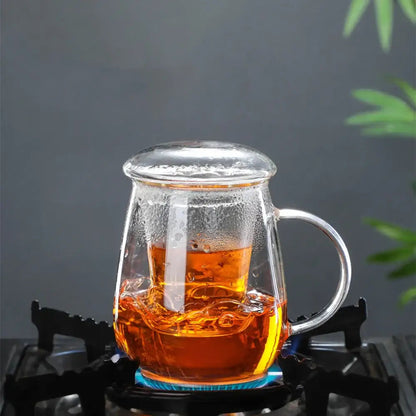 Pouring tea from small glass teapot into cup