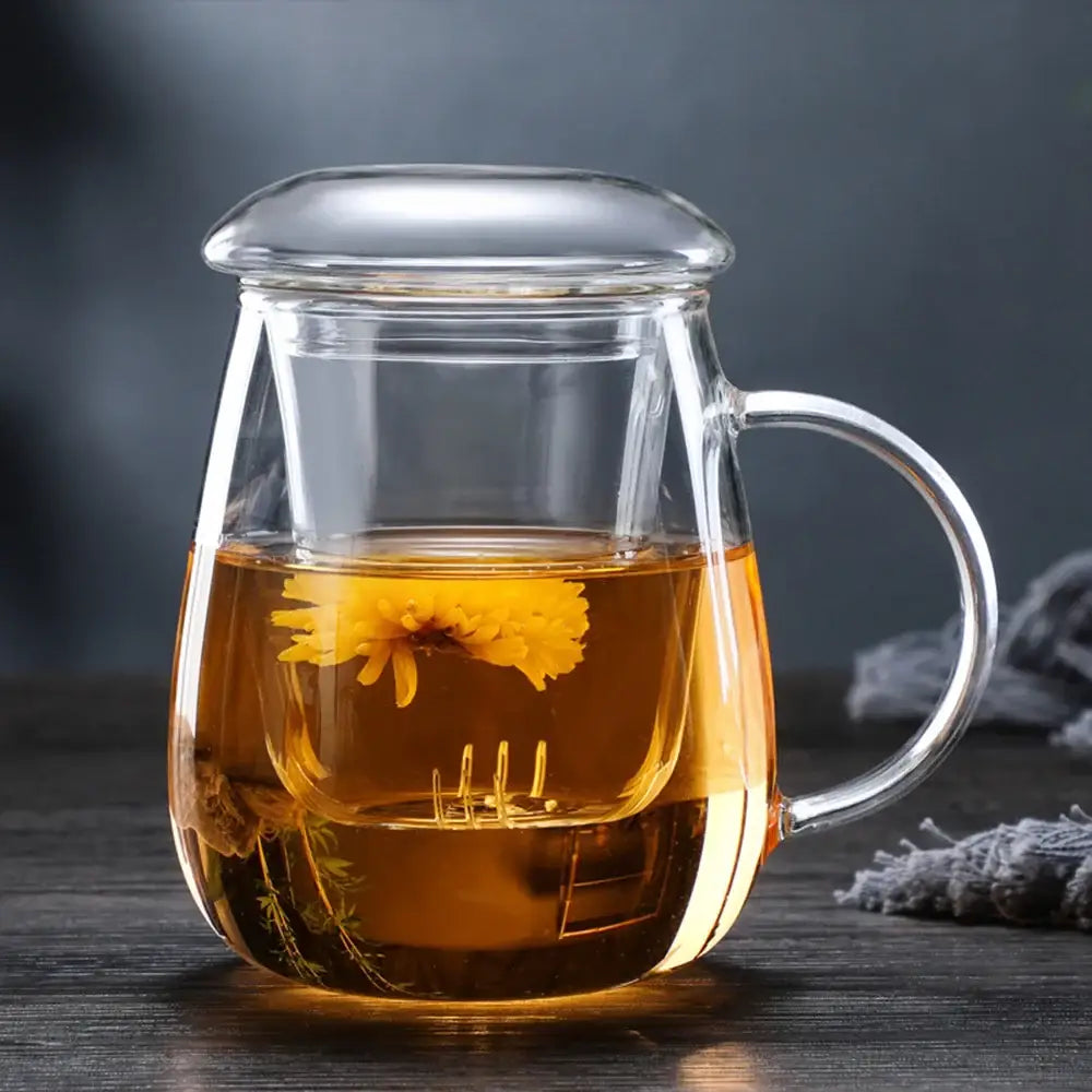 Hand holding small glass teapot by handle