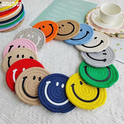 Smiley coaster under a teacup on a wooden table