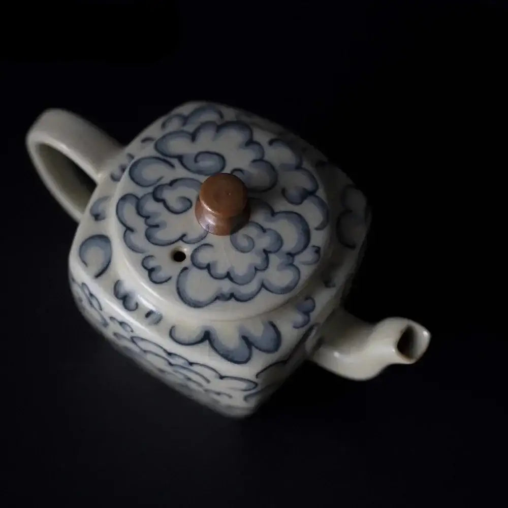 Close up of square porcelain teapot with tea cup