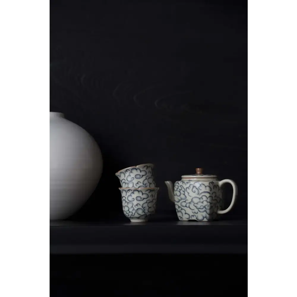 Square porcelain teapot pouring tea into cup