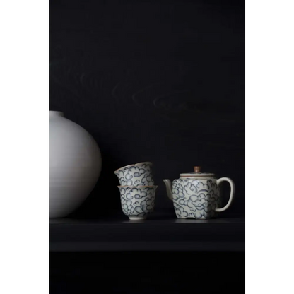 Square porcelain teapot pouring tea into cup