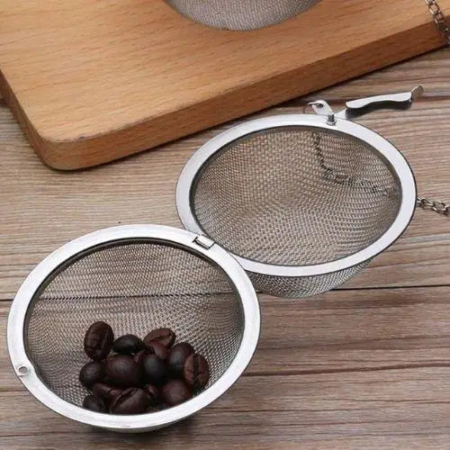 Ball tea infuser steeping loose leaf tea inside a white mug