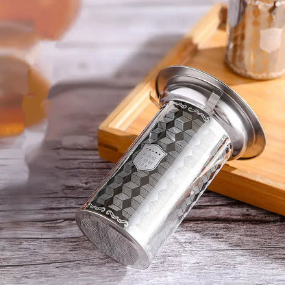 Tea infuser being placed into a mug of hot water