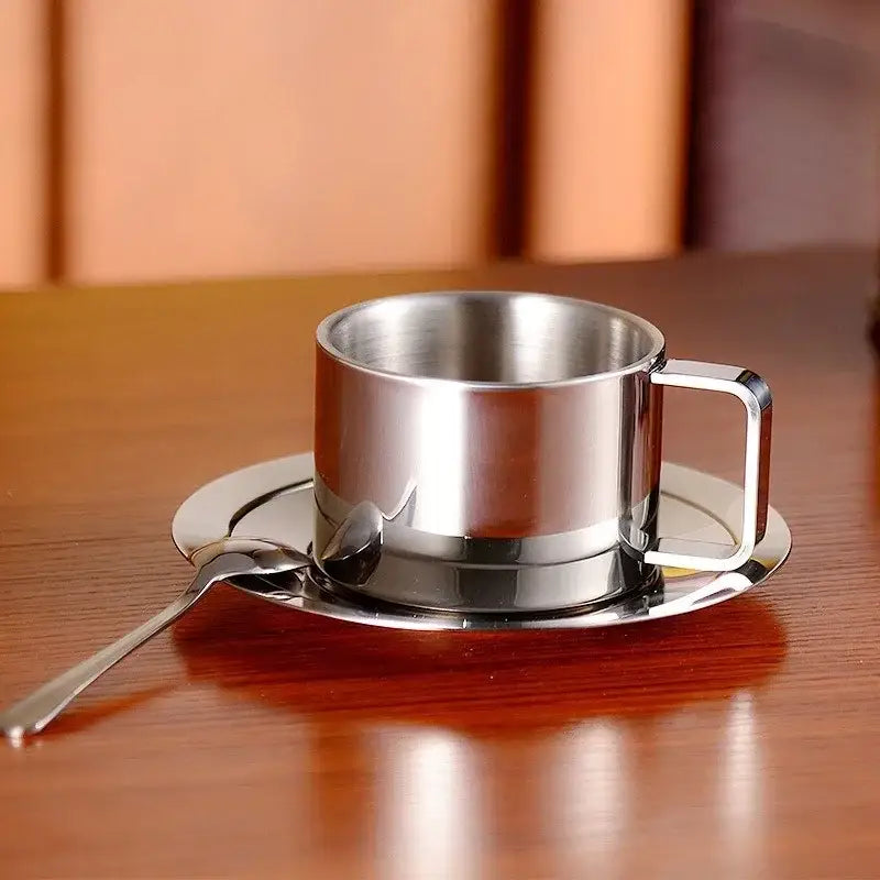 Stainless steel saucer set with cup and spoon on table