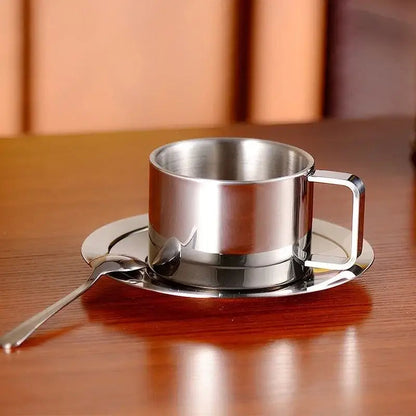 Stainless steel saucer set with cup and spoon on table