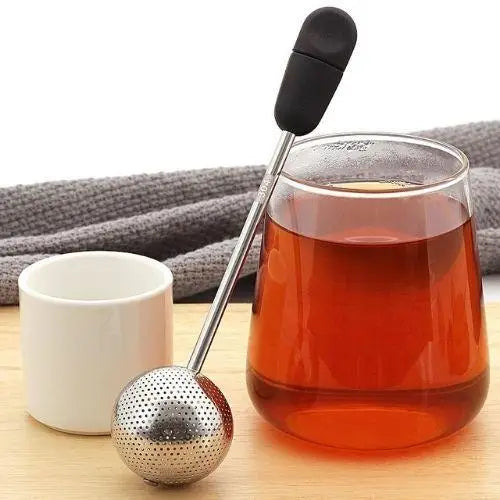 Stainless steel tea infuser ball steeping loose leaf tea in a ceramic mug