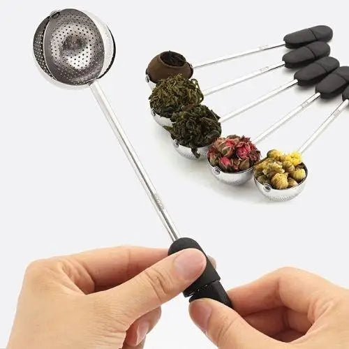 Tea infuser ball open on hinge filled with loose leaf tea leaves