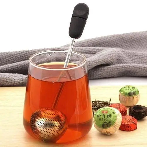 Tea infuser ball with steam rising from mug, Magic Handle visible above water line