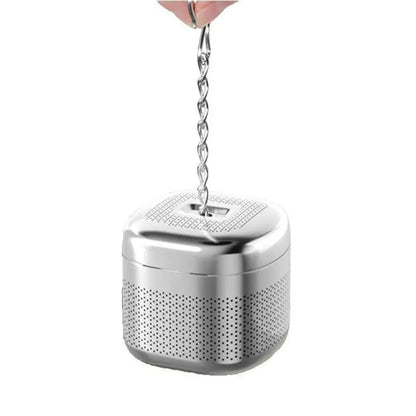 Cube tea infuser for loose leaf inside a clear glass teapot